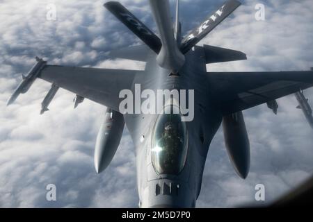 USA Air Force Captain Scott Wawrzyniak, F-16 Fighting Falcon Pilot, dem 52. Kampfflugflügel zugeteilt, erhält Treibstoff von einem KC-135 Stratotanker Flugzeug, das dem 100. Air Tanken Flügel zugeteilt wurde, 3. März 2022. USA Die Streitkräfte in Europa leben, trainieren und arbeiten mit Verbündeten und Partnern von strategischen Standorten in ganz Europa zusammen, die für eine rechtzeitige und koordinierte Reaktion in Friedenszeiten und Krisen von entscheidender Bedeutung sind. Stockfoto