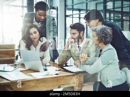 Hier kommen die größten Ideen her. Ein Unternehmensteam, das ein Meeting in seinem Büro abhält. Stockfoto