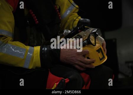 Ein Alaska Air National Guard Sanitäter, der der 212. Rettungsschwadron, Alaska Air National Guard, zugeteilt wurde, bereitet seinen Helm für Lufteinsätze in den Pazifik nahe Homer, Alaska, am 3. März 2022 vor. Die AKANG führte eine Übung mit der 212. Rettungsschwadron durch, um eine Wasserrettung zu simulieren. Die Garde führt regelmäßige Schulungen durch, um die Einsatzbereitschaft für zivile Such- und Rettungsmissionen sowie für Notfalleinsätze aufrechtzuerhalten. Stockfoto