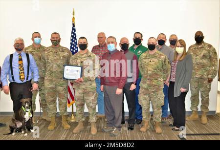 Mitglieder des Teams Fort McCoy, Wisconsin, Garrison halten für ein Foto am 3. März 2022, mit einem besonderen Zertifikat, das vom befehlshabenden General der 88. Readiness Division und dem ranghohen Befehlshaber von Fort McCoy, Generalleutnant Darrell J. Guthrie, für die Unterstützung der Garnison für die Operation Alliierte ausgestellt wurde. Willkommen vom 15. August 2021. Bis zum 15. Februar. Das Zeugnis ist ein 88. Readiness Division befehlshabender Blue Devil Award des Generals, der „in Anerkennung der herausragenden Unterstützung, die der Task Force McCoy während der Operation Allies Welcome Mission gewährt wurde“, verliehen wird. In der Auszeichnung heißt es weiter: „Ihr Team hat Tausende afghanischer Indiv unterstützt Stockfoto