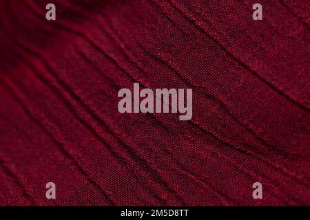 Rotes Textilmuster auf dem Hintergrund. Rotes Stoffgewebe Textilmaterial. Stockfoto