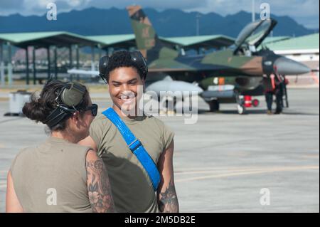 USA Air Force Staff Sgt. Rachelle Bellini und Airman 1. Class Aaron Williams, 18. Aircraft Maintenance Unit Waffenladungsteams, koordiniert F-16 Fighting Falcon Maintenance, 3. März 2022, auf der Joint Base Pearl Harbor-Hickam, Hawaii. Die Airmen zogen vorübergehend nach Hawaii um, um an der Übung Pacific Raptor teilzunehmen, einer Übung zur Integration von Flugzeugen der fünften Generation mit F-16 „Aggressoren“ Die Ausbildungsaktivitäten von Pacific Raptor umfassten eine Simulation des Luft-Luft- und Luft-Boden-Kampftrainings, das aus Tarnflugzeugen gegen hoch entwickelte Bedrohungen bestand. Stockfoto