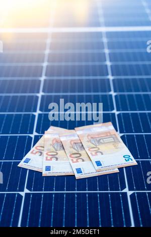 Energiesparkonzept mit Solarmodulen und 50-Euro-Scheinen Stockfoto