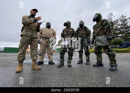 USA Staff Sgt. Scott Nelson, Left, ein Spezialist für Notfallmanagement beim 129. Geschwader der California Air National Guard, 129. Rescue Wing, spricht während eines chemischen, biologischen, radiologischen und nuklearen Trainingskurses am 4. März 2022 mit den Flugzeugen an einem Kontrollpunkt. Am Luftwaffenstützpunkt Moffett in der Nähe von Mountain View, Kalifornien. Die routinemäßige Schulung ist für Airmen alle zwei Jahre erforderlich. Stockfoto