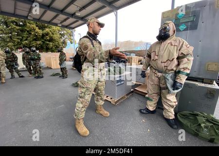 USA Staff Sgt. Scott Nelson, Left, ein Spezialist für Notfallmanagement beim 129. Ziviltechniker-Geschwader der California Air National Guard, 129. Rescue Wing, spricht mit Senior Airman Ajani Spicer-Grose, Right, vom 129. Wartungsgeschwader, während eines chemischen, biologischen, radiologischen und nuklearen Trainingskurses, 4. März 2022, Am Luftwaffenstützpunkt Moffett in der Nähe von Mountain View, Kalifornien. Die routinemäßige Schulung ist für Airmen alle zwei Jahre erforderlich. Stockfoto