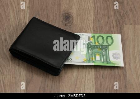 100 Euro aus der Brieftasche. Eine Papierbanknote im Wert von 100 Euro. Symbol für wachsende Ausgaben, Inflation, Zahlung von Haushaltsrechnungen, Gehalt, Bonus, Stockfoto