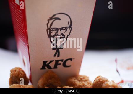 Gebratenes Popcorn-Hähnchen auf dem Restaurantteller mit natürlichem Sonnenlicht. KFC Restaurant. KFC ist eine beliebte Fast-Food-Kette, bekannt als Kentucky Fried Chicken. Stockfoto