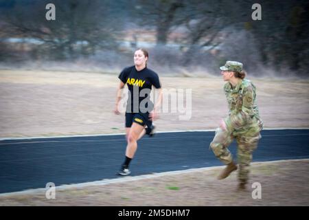 USA Army Reserve Sgt. 1. Klasse Karla Parker, 2. Medical Brigade Sponser, Prost auf PFC Taylynn Cross, 2. Medical Brigade Wettbewerber, während der ACFT beim Consortium Best Warrior Competition in Camp Bullis, Texas am 4. März 2022. Stockfoto