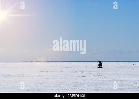 Eisangeln. Winterfischerei auf Eis auf See, Estland. Stockfoto