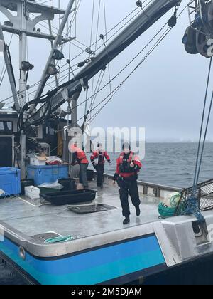 Ein Boarding-Team von der Küstenwache Valdez führt eine Sicherheitsinspektion eines Fischereifahrzeugs durch, das sich für die Heilbuttsaison in der Nähe des Hafens von Valdez, Alaska, am 4. März 2022 bereitstellt. Die Besatzungen von Station Valdez führen das ganze Jahr über Sicherheitsuntersuchungen durch und setzen die Sicherheits- und Fischereigesetze in Prince William Sound durch. USA Foto der Küstenwache von Petty Officer 3. Class Dayton Deckard. Stockfoto