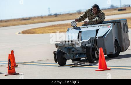 USA Air Force Master Sgt. Clifton Wells, 27. Special Operations Maintenance Group First Sergeant, fährt während eines Jammer-Jamborees einen Waffenjammer zwischen den Hütchen, als Teil des 27. Special Operations Maintenance Group 2021 Annual Load Crew of the Year Wettbewerbs am Cannon Air Force Base, New Mexico, 4. März 2022. Der Jammer-Jamboree ist ein Wettkampf, bei dem bewaffnete Besatzungsmitglieder und andere Mitarbeiter aus der Basis darauf abgestimmt sind, wie schnell sie einen Jammer durch einen Hindernisparcours fahren können. Stockfoto