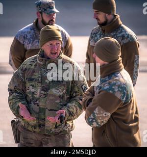 USA Army Chief Warrant Officer 3 Taylor, der der 164. Artilleriebrigade der Florida National Guard zugeteilt wurde, diskutiert mit Air Defenders der lettischen Air Force während der Übung Saber Strike 22 am 4. März 2022 in Adazi, Lettland, über Luftabwehrtechniken und -Taktiken. Die beiden Einheiten verbrachten den Tag mit Cross-Training zu Ausrüstung und Verfahren, um die Interoperabilität der Kurzstreckenflugsicherung weiter zu verbessern. Die Übung läuft bis März mit etwa 13.000 Teilnehmern aus 13 Ländern und findet seit 2010 alle 2 Jahre statt. Die Schulungsveranstaltung ist geplant Stockfoto