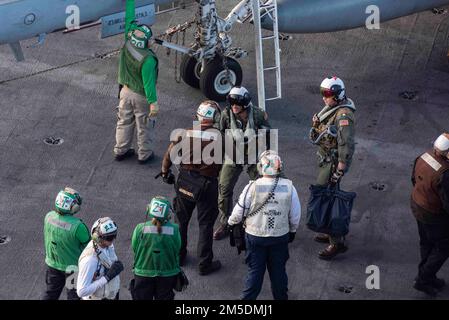 220304-N-XK462-1266 PAZIFIK (4. März 2022) Kapitän Craig Sicola, Befehlshaber der USS Nimitz (CVN 68), schüttelt einem Matrosen die Hand auf dem Flugdeck des Nimitz. Nimitz führt gerade Routineoperationen durch. Stockfoto