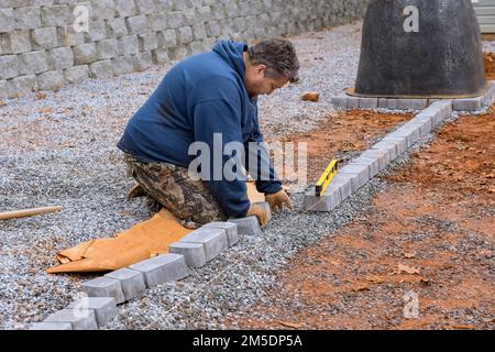 Deckenfertiger Steinpflaster legt Pflastersteine mit einem professionellen Deckenfertiger Stockfoto