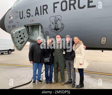 Major Evan Gibson (Zentrum), 173. Air Tanken Squadron KC-135 Stratotanker Pilot steht mit Familie und feiert seinen letzten Flug, 5. März 2022, Lincoln Air Force Base, Nebraska. Gibsons Familie und seine Kollegen bei Airmen gratulieren ihm zu seinen beruflichen Leistungen. Stockfoto