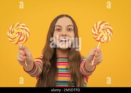 Hipster Teenager Kind Mädchen lecken Lollypop. Zucker Ernährung, Süßigkeiten und Süßigkeiten. Kind isst Lollipop-Popsicle. Stockfoto