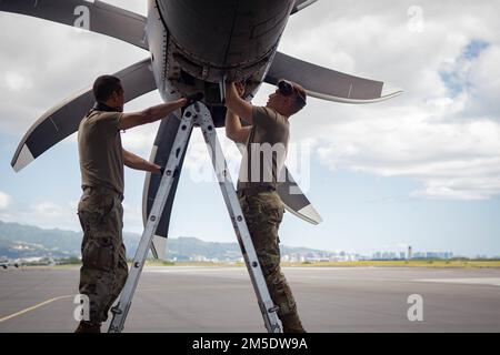 Flugzeuge der 152. Maintenance Group inspizieren den Motor eines Flugzeugs der Nevada Air National Guard C-130 Hercules nach einem Flug im Rahmen einer Übungsübung auf der Hickam Air Force Base, Hawaii, 3. März 2022. Die Airmen arbeiteten daran, sicherzustellen, dass die beiden C-27, die die Nevada Guard zur dreitägigen Ho’oikaika 22-1-Übung auf Hawaii mitbrachte, effektiv und sicher flogen. Stockfoto