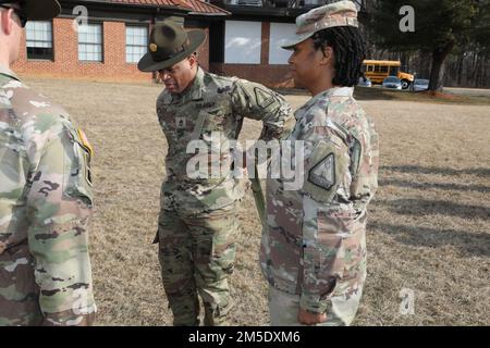 Sgt. 1. Class Quintin Queen, Senior Drill Sergeant, Maryland National Guard, Rekrutierungs- und Retentionsbataillon, probiert den Senior Drill Sergeant Gürtel zum ersten Mal während einer Zeremonie zum De-Hatting und Verantwortungswechsel im Camp Fretterd Military Reservation in Reisterstown, Maryland, am 5. März 2022. Die De-Hatting-Zeremonie ist eine symbolische Tradition, bei der Drillsergeants nach Abschluss ihrer Tour ihre Wahlkampfhüte in den Ruhestand setzen. Stockfoto