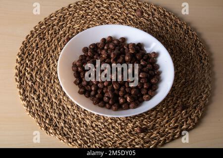 Süße braune Bälle auf einer weißen Platte auf einer Strohbasis Stockfoto