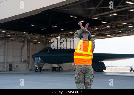 Senior Airman Breandan M. Hensley, Crewchef der 131. Flugzeugwartungsstaffel, Marshalls LT. Colonel Timothy Sullivan, 131. Bombenflügelpilot, als er den B-2 Spirit Tarnbomber am 5. März 2022 auf die Rollbahn am Whiteman Luftwaffenstützpunkt, Missouri leitet. Sullivan flog seinen letzten Flug, in dem er auch 1500 Stunden in der B-2 übertraf. Stockfoto