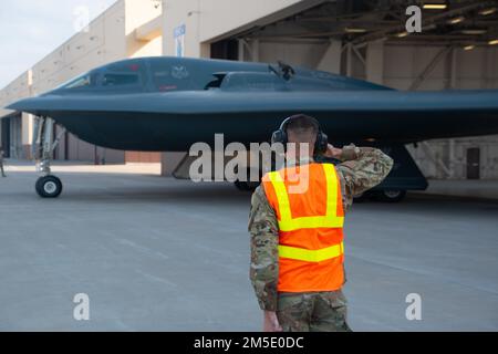 Senior Airman Breandan M. Hensley, Crewchef der 131. Flugzeugwartungsstaffel, Marshalls LT. Colonel Timothy Sullivan, 131. Bombenflügelpilot, als er den B-2 Spirit Tarnbomber am 5. März 2022 auf die Rollbahn am Whiteman Luftwaffenstützpunkt, Missouri leitet. Sullivan flog seinen letzten Flug, in dem er auch 1500 Stunden in der B-2 übertraf. Stockfoto