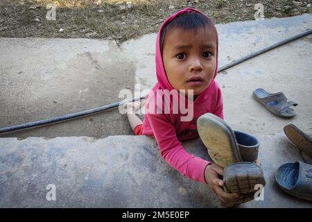 Dhading, Bagmati, Nepal. 27. Dezember 2022. Ein Kind aus der Gemeinde Chepang wartet auf warme Kleidung im Dorf Hekrang von Benighat Rorang im Dhading-Viertel, ca. 55 km von der Hauptstadt Kathmandu, Nepal, am 27. Dezember 2022. Heartbeat, eine soziale Organisation zusammen mit einzelnen Spendern, verteilte warme Kleidung und Schreibwaren, Kunstmaterialien, Essen an Kinder der Chepang Gemeinde, warme Kleidung an Familienmitglieder. (Kreditbild: © Sunil Sharma/ZUMA Press Wire) Stockfoto