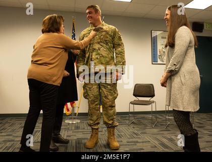USA Air Force Captain Benjamin Garland erhält seinen neuen Rang von seiner Großmutter, während seine Mutter und Schwester während seiner Beförderung zum Major auf der Buckley Space Force Base, Aurora, Colorado, am 6. März 2022 zuschauen. Garland ist Absolvent der Air Force Academy und wurde 2010 in die National Football League aufgenommen. Derzeit ist Garland das Dienstmitglied mit der höchsten Rangfolge, das auch in der NFL gespielt hat. Stockfoto