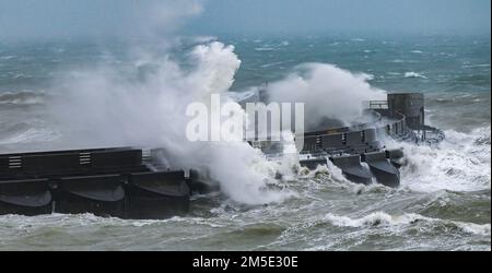 Brighton UK 28. Dezember 2022 - riesige Wellen stürzen über den westlichen Arm der Brighton Marina an einem nassen und windigen Tag an der Südküste. : Credit Simon Dack / Alamy Live News Stockfoto