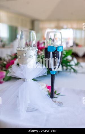 Wunderschön dekorierte Champagnergläser für frisch Vermählte mit Blumen. Stockfoto