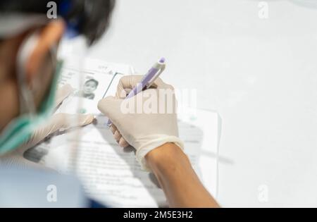 Polizist füllt Impfstoff-Formular für Screen-Historie aus, bevor er Impfstoff bekommen hat. Stockfoto