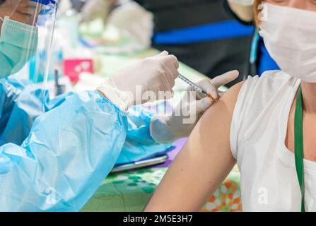 Hausarzt-Impfung der jungen Frau in der Klinik. Arzt, der der Frau im Krankenhaus eine Injektion gibt. Stockfoto