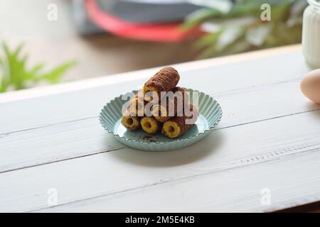 Ein selektiver Fokus auf Süßigkeiten, serviert mit einem blauen Teller auf einem Holztablett Stockfoto