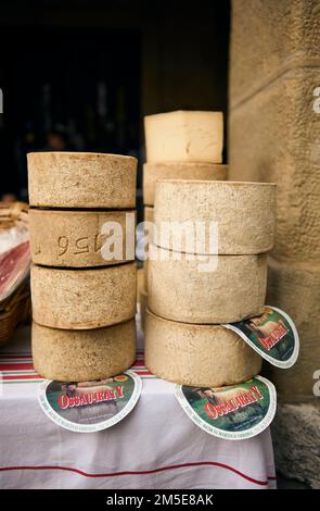 Ein Haufen Ossau-Iraty Käseräder, ein typischer baskischer Käse, auf einem Markt. Stockfoto