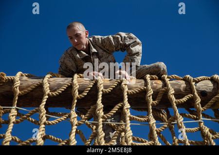 EIN US-AMERIKANISCHER Marine Corps Rekruten bei Golf Company, 2. Recruit Training Battalions navigiert das Hindernis beim Aufstieg des Frachtnetzes während des Konfidenzkurses im Marine Corps Recruit Depot San Diego, 7. März 2022. Rekruten wurden körperlich und geistig stärker, indem sie Hindernisse überwunden haben, die Stärke, Ausgewogenheit und Entschlossenheit erfordern. Stockfoto