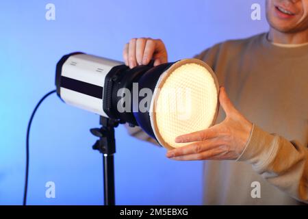 Ein Blitz mit einem Modifikator an und ein Diffusor mit einer Person im Hintergrund Stockfoto