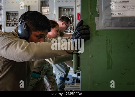 USA Air Force Airmen beladen eine Palette auf eine C-17 Globemaster III, die dem 437. Airlift-Flügel zugeteilt wurde, während eines Zwischenstopps am Pope Army Airfield, North Carolina, 7. März 2022. Die 437 AW liefert Passagiere, Ausrüstung und Vorräte, wann und wo immer sie benötigt werden, per Flugzeug, zu Land oder per Abwurf. Stockfoto