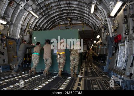 USA Air Force Chief Master Sgt. Raun Howell, 437. Airlift Wing Command Chief, unterstützt die Flugzeuge beim Verladen einer Palette auf einen C-17 Globemaster III, der dem 437. Airlift Wing zugeteilt wurde, während eines Zwischenstopps am Pope Army Airfield, North Carolina, 7. März 2022. Die 437 AW liefert Passagiere, Ausrüstung und Vorräte, wann und wo immer sie benötigt werden, per Flugzeug, zu Land oder per Abwurf. Stockfoto