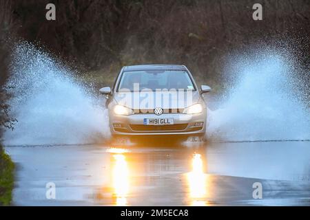 Muckleford, Dorset, Großbritannien. 28. Dezember 2022 Wetter in Großbritannien. Nach einem Tag voller Regen und starkem Wind fährt ein Auto auf einer Straße in Muckleford in der Nähe von Dorchester in Dorset durch Hochwasser. Bildnachweis: Graham Hunt/Alamy Live News Stockfoto