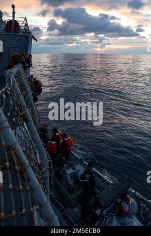 220307-N-UN585-1048 MITTELMEER (7. März 2022) Seeleute, die dem Arleigh-Burke-Klasse-Guided-Missile Destroyer USS Ross (DDG 71) zugeteilt wurden, gehen vom französischen Schiff FS Forbin (D620) an Bord eines aufblasbaren Rumpf-Starrrumpfboots, März 7. Ross, nach Rota, Spanien, ist auf seiner 12. Patrouille in den USA Sechster Einsatzbereich der Flotte zur Unterstützung regionaler Verbündeter und Partner sowie nationaler Sicherheitsinteressen der USA in Europa und Afrika. Stockfoto