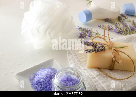 Badprodukte mit Lavendelextrakt mit Elementen für die Körperhygiene auf dem weißen Tisch. Erhöhte Aussicht. Horizontale Zusammensetzung. Stockfoto