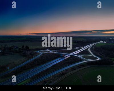 Eine Luftaufnahme einer Kreuzung auf der A14 Trunk Road bei Sonnenaufgang in Suffolk, Großbritannien Stockfoto