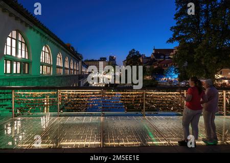 Stadt Ljubljana in Slowenien, die Metzgerbrücke (slowenisch: Am meisten Mesarski) mit Liebesschlössern am Fluss Ljubljanica und den Plecnik Arcades. Stockfoto