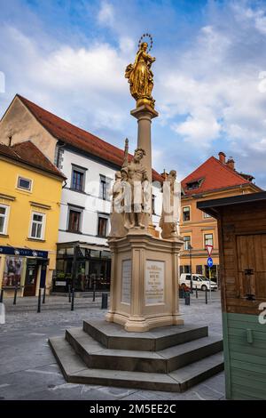 Säule der Heiligen Maria in Celje, Slowenien. Säule mit der Statue der vergoldeten Jungfrau Maria, 1776 errichtetes Denkmal, barocke Statuen von St. Roch, Stockfoto