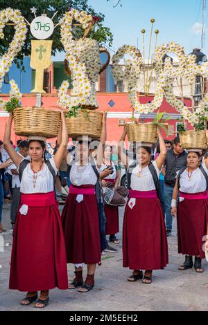 Canastera-Tänzer aus Tlacolula in traditionellen Kleidern mit Blumenkörben vor der Guelaguetza-Parade in Oaxaca, Mexiko. Stockfoto