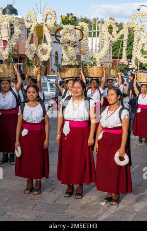 Canastera-Tänzer aus Tlacolula in traditionellen Kleidern mit Blumenkörben vor der Guelaguetza-Parade in Oaxaca, Mexiko. Stockfoto