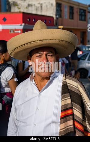 Ein Tänzer aus Tlacolula in traditioneller Kleidung mit Sombrero und Serape bei der Guelaguetza-Parade in Oaxaca, Mexiko. Stockfoto