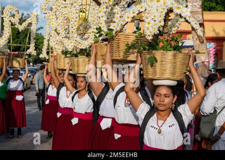 Canastera-Tänzer aus Tlacolula in traditionellen Kleidern mit Blumenkörben vor der Guelaguetza-Parade in Oaxaca, Mexiko. Stockfoto