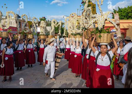 Canastera-Tänzer aus Tlacolula in traditionellen Kleidern mit Blumenkörben vor der Guelaguetza-Parade in Oaxaca, Mexiko. Stockfoto