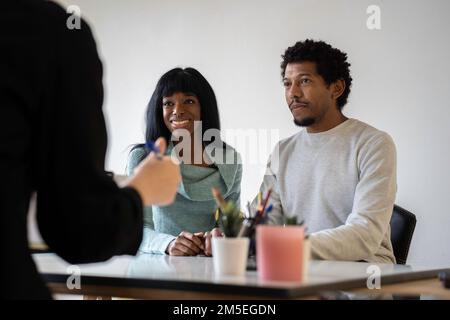 afroamerikanisches Paar, das für eine Paartherapie in der Praxis eines Psychologen sitzt - Beziehungskonzept in Schwierigkeiten und Krise - Fokus auf Frauen Stockfoto