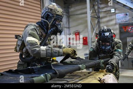 Während einer Routineübung zum Bereitschaftstraining am Luftwaffenstützpunkt Kadena am 8. März 2022 bringen die Mitarbeiter der 31.-Rettungstruppe einen Abfall an einem Geländefahrzeug an. Während der Schulung üben die Kadena-Mitglieder Mobilisierungsverfahren und führen Schulungsaktivitäten durch, um die technischen Fähigkeiten zu verbessern und die Einsatzbereitschaft der Basis zu verbessern. Stockfoto